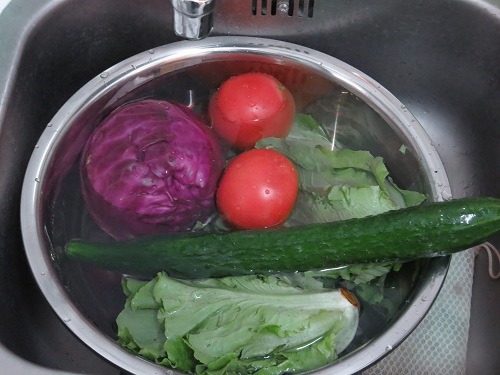 （写真４）水道水につけている野菜、ゴシゴシ葉っぱを擦るといいらしい