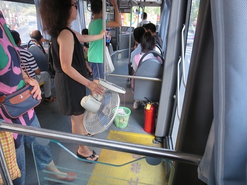 （写真１）扇風機を片手にもつ中国人の女性（上海市内）