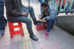 （写真１）路上で靴磨きをしているおばさん（広州市内）
